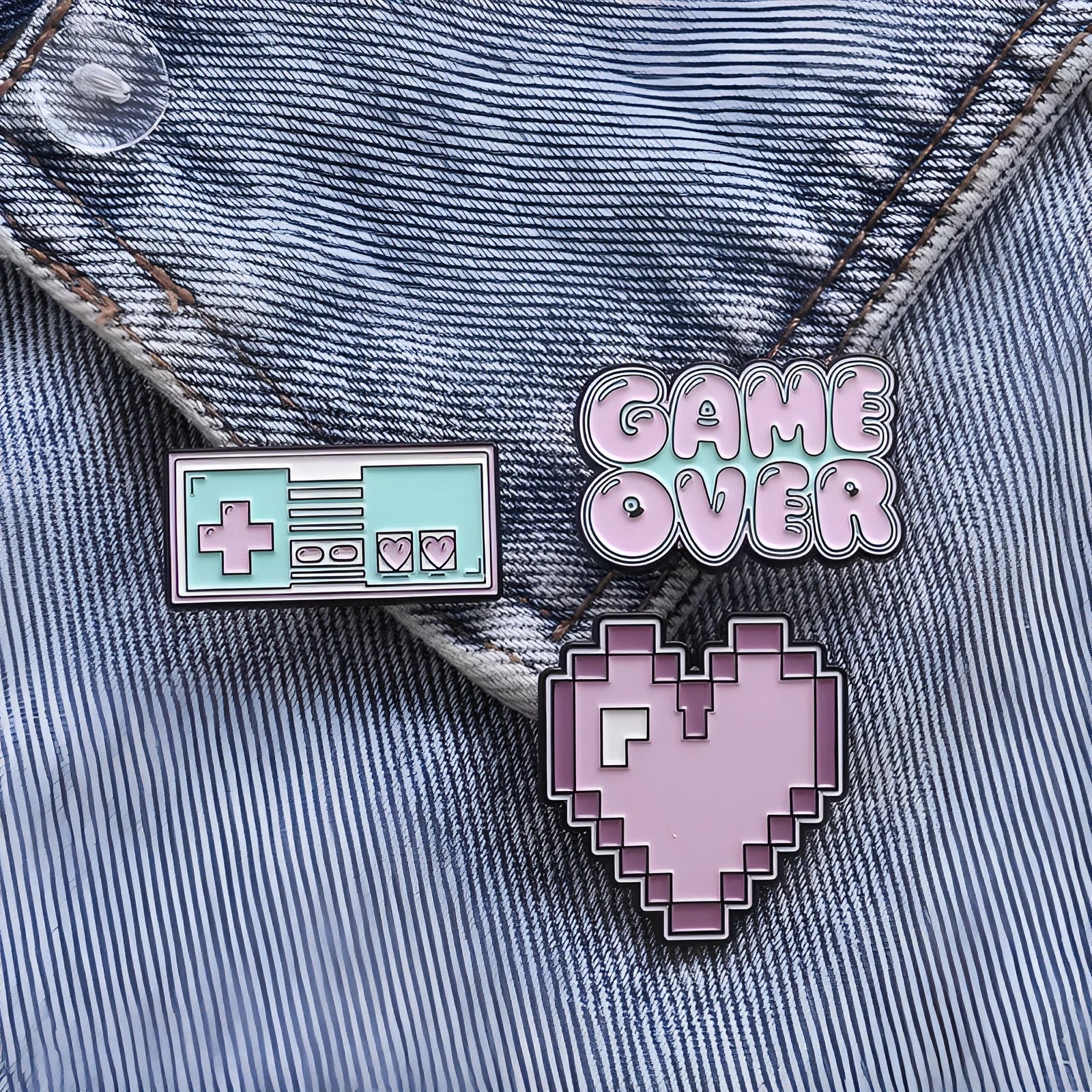 Stereo game console badge made of alloy metal in a three-dimensional design, shown in its OPP packaging.