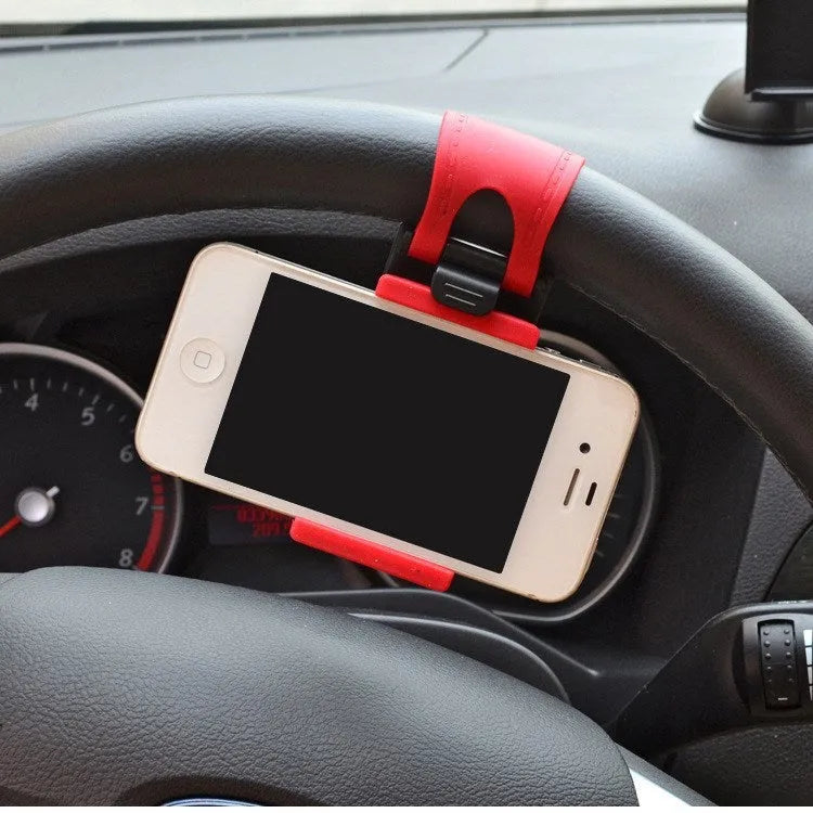 Black universal steering wheel phone holder clip mounted on a car steering wheel, holding a smartphone.