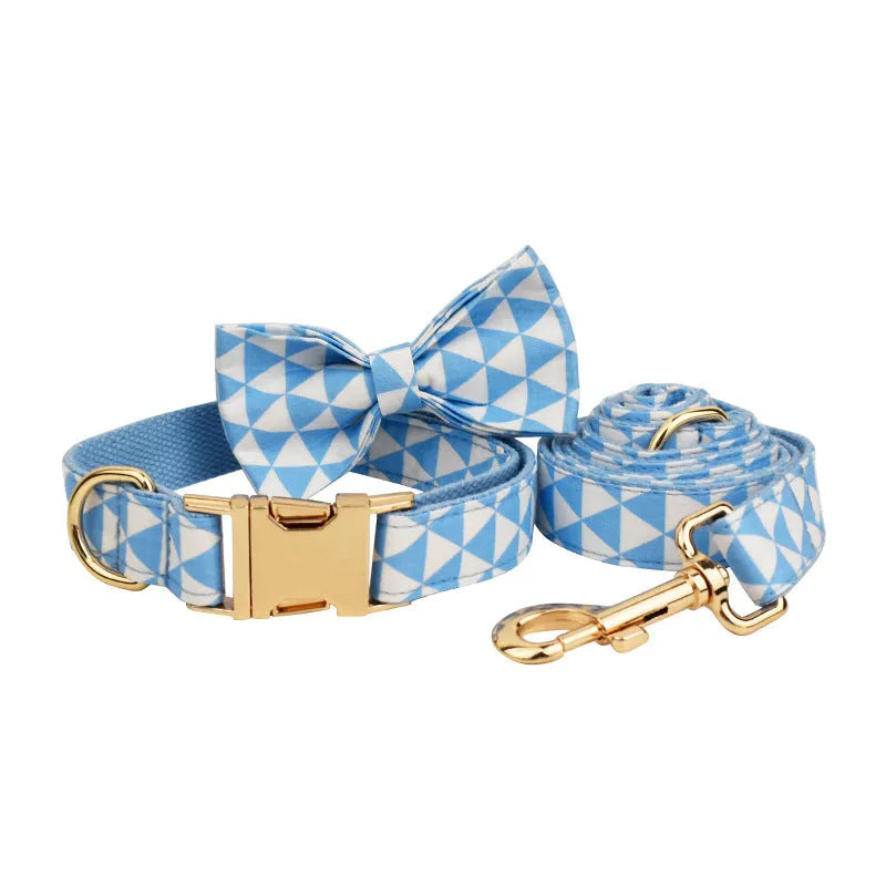 Blue cloth dog collar, lead, bow, and vest set laid out flat showing the four matching pieces.