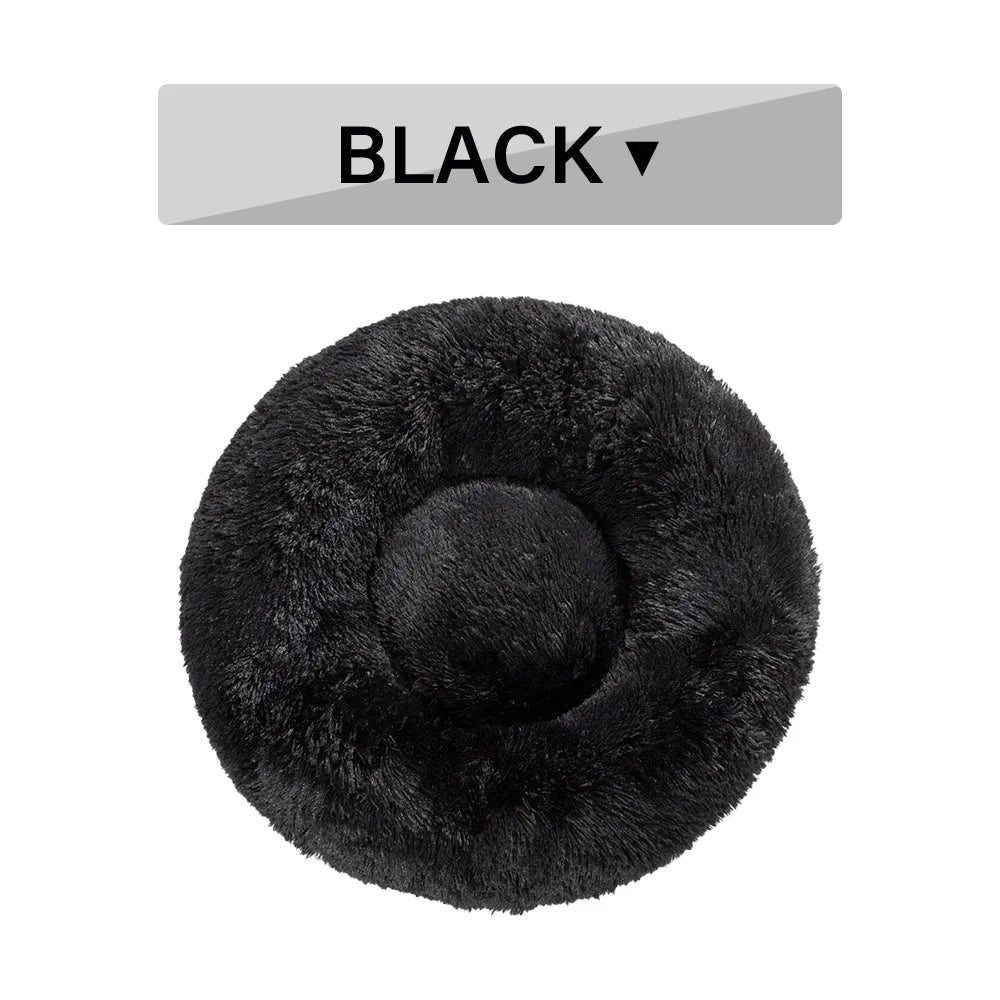 A fluffy, round donut-shaped dog bed with a raised rim in long plush fabric.
