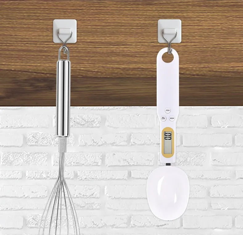 Black electronic measuring spoon scale with digital display showing weight measurement