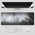Black thickened non-slip mouse pad with rubber base and cloth surface on a desk