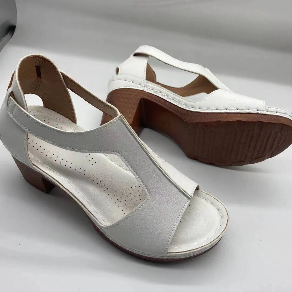 Women's white peep toe wedge sandals with a buckle strap on a slingback heel.