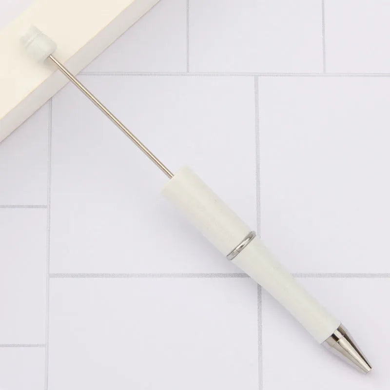 Colourful spinning ballpoint pen with plastic beads on a white background.