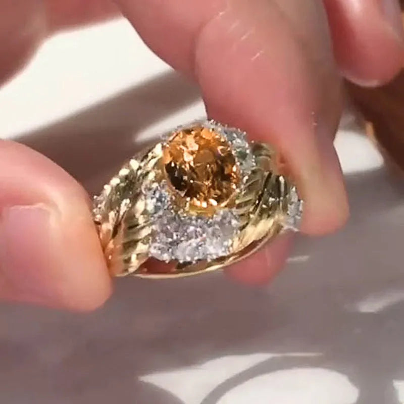 Gold feather embossed women's ring with a yellow zircon stone on a geometric copper band.
