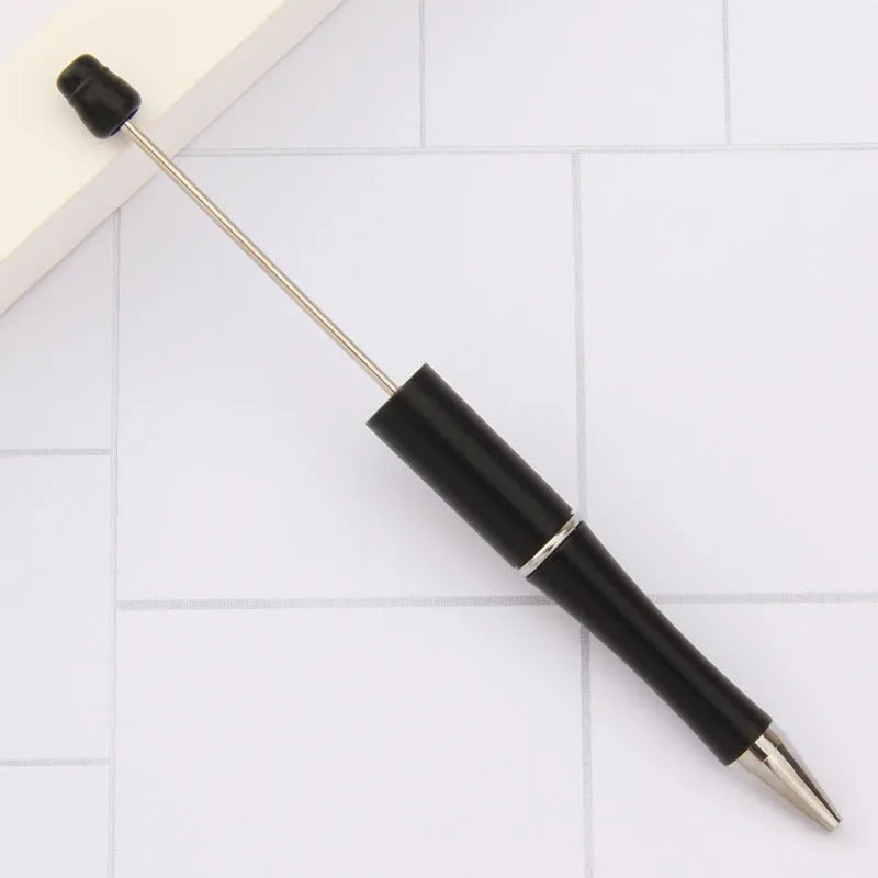 Colourful spinning ballpoint pen with plastic beads on a white background.