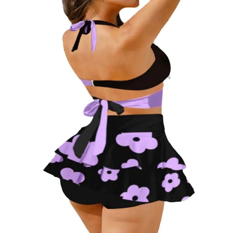 Purple women's bikini set with lace-up front and high-waisted split skirt.