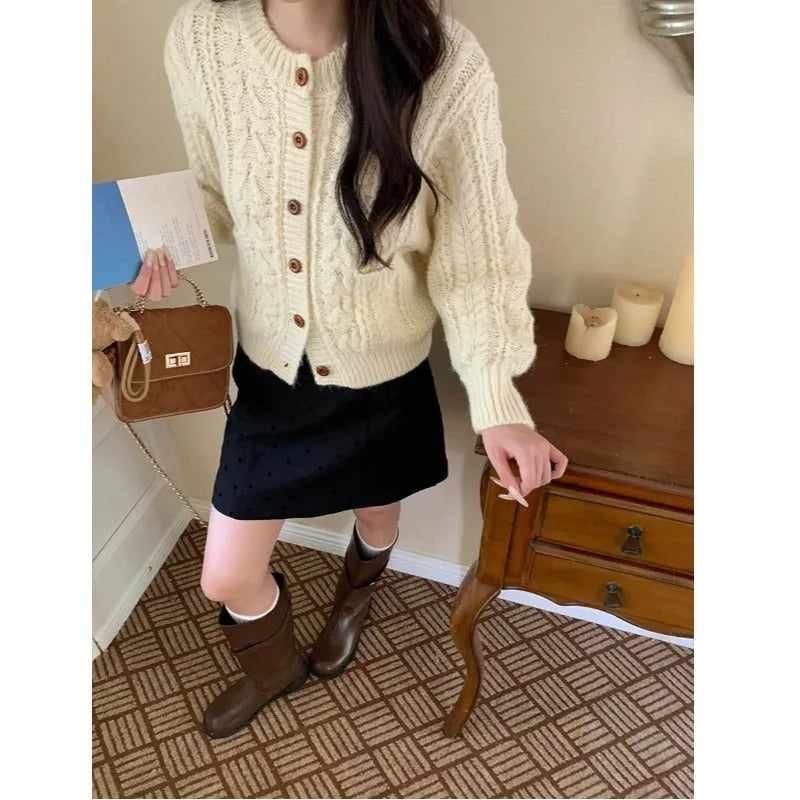 Solid colour thick needle twisted texture knitted cardigan in beige, short length, on model