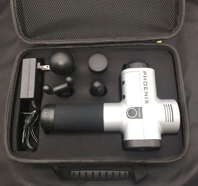 Black ABS fascia massage gun with four different coloured attachment heads on a grey surface.