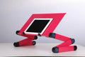Black folding laptop table stand with six legs, magnesium alloy desktop, and attached mouse pad, folded view on a desk