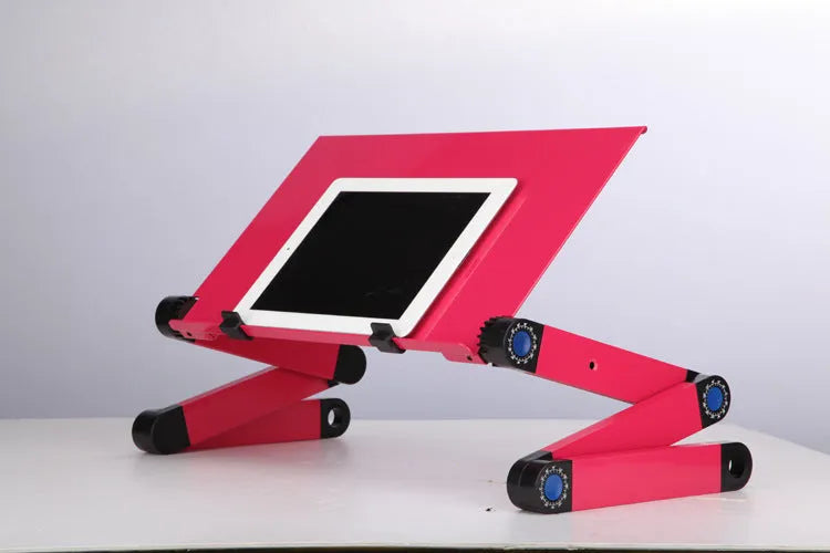 Black folding laptop table stand with six legs, magnesium alloy desktop, and attached mouse pad, folded view on a desk