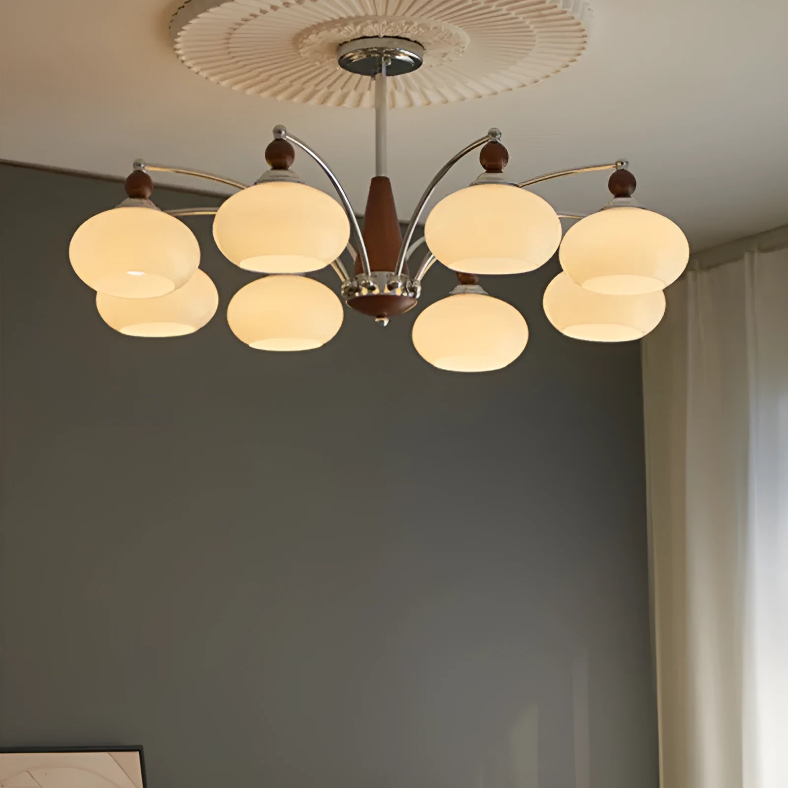 Persimmon glass chandelier with multiple chrome lampshades in a Middle Ancient style, hung from a ceiling.
