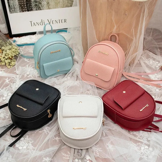 Small black PU women's shoulder backpack with zipper, shown next to a mobile phone for scale.