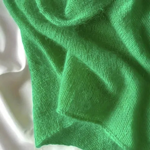 Green crew neck loose fit long sleeve polyester pullover sweater for women on plain background