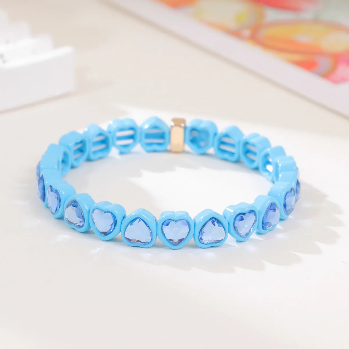 Rainbow enamel heart charm bracelet on alloy base with diamond treatment, stretch band, multicolour design.