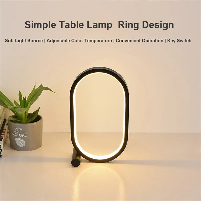 USB plug-in oval acrylic touch control night light with metal base, black finish, on a bedside table