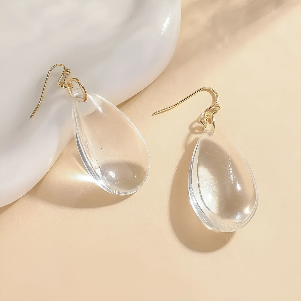 Transparent glass or crystal teardrop drop earrings with irregular shape and cold-tone finish for women