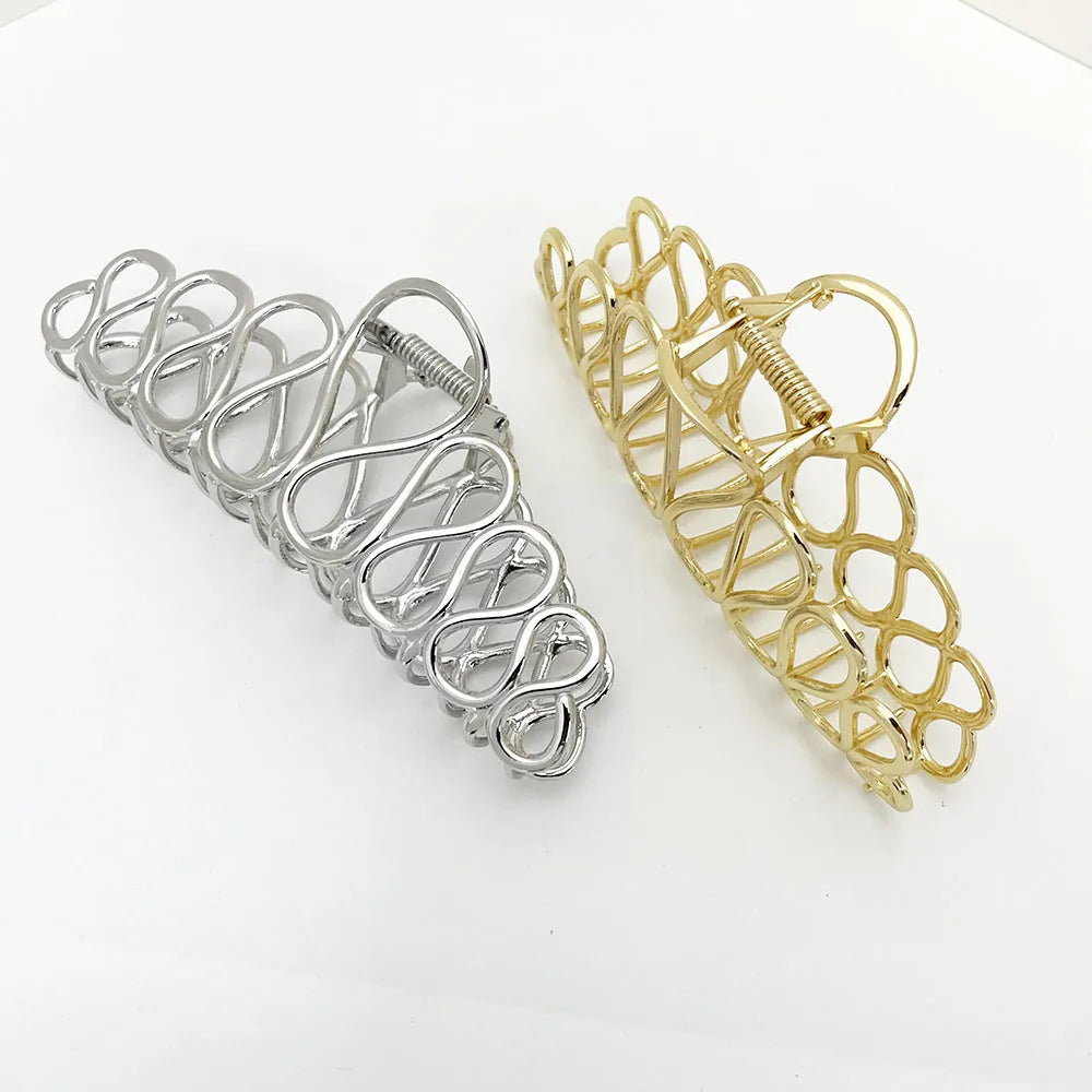Minimalist large hair clip with gold electroplated finish and tassel detail on irregular geometric alloy design