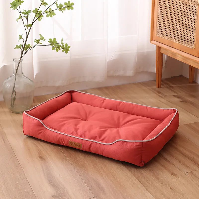 Grey waterproof dog sofa bed with raised edges on wooden floor