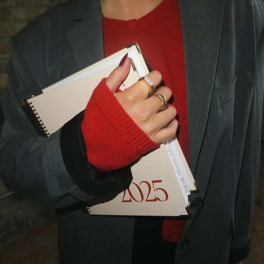 Cherry red coil-bound notebook open on desk showing flat-lying pages for comfortable writing