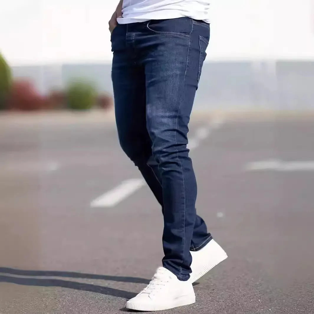 Men's dark blue slim fit skinny jeans on a hanger, showing mid waist and zipper fly detail.