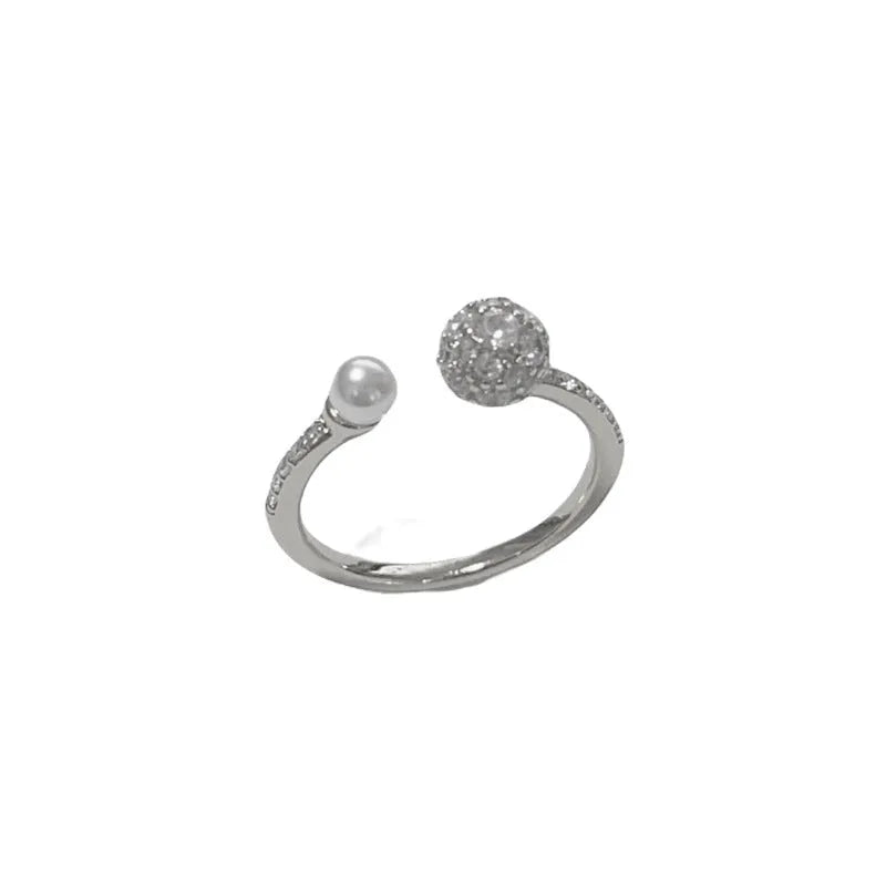 Gold or silver coloured open-end ring with a round zircon pearl on a geometric band.