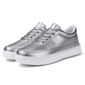 Women's leather flat casual shoes in gold colour with front lace-up closure on a white background.