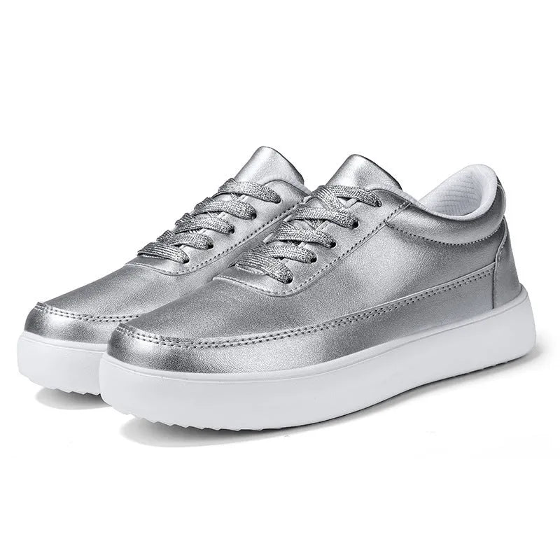 Women's leather flat casual shoes in gold colour with front lace-up closure on a white background.
