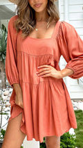 Orange children's backless dress with square collar and puff sleeves on hanger