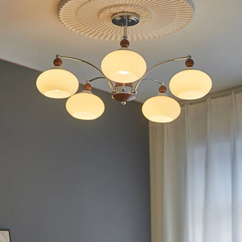 Persimmon glass chandelier with multiple chrome lampshades in a Middle Ancient style, hung from a ceiling.