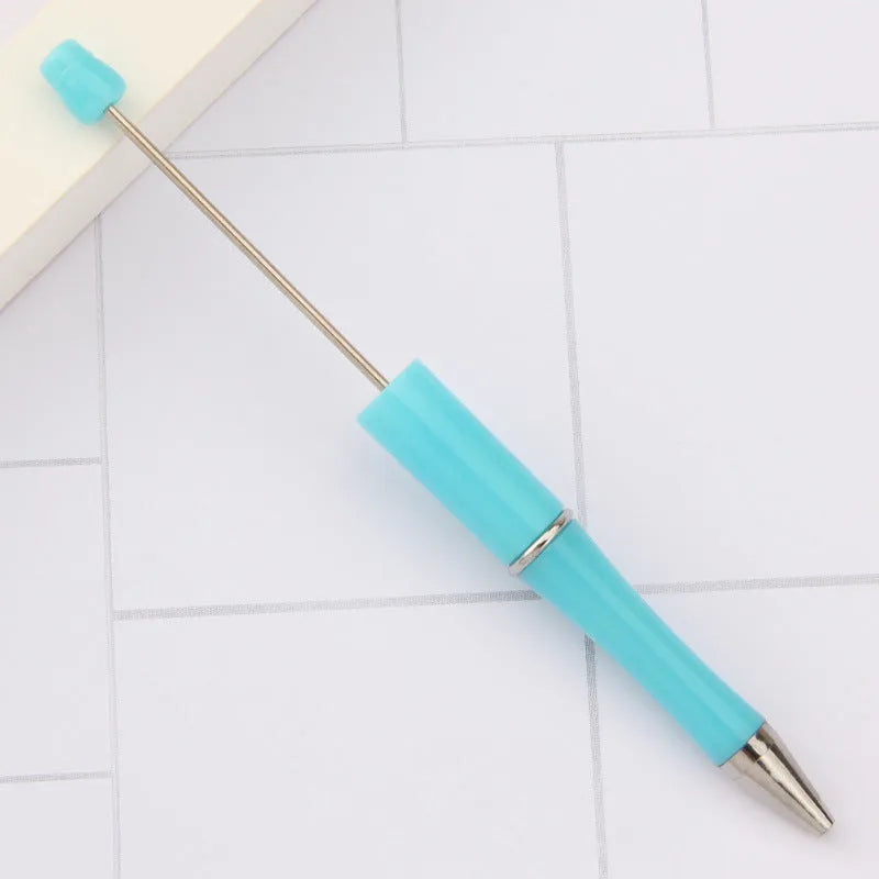 Colourful spinning ballpoint pen with plastic beads on a white background.