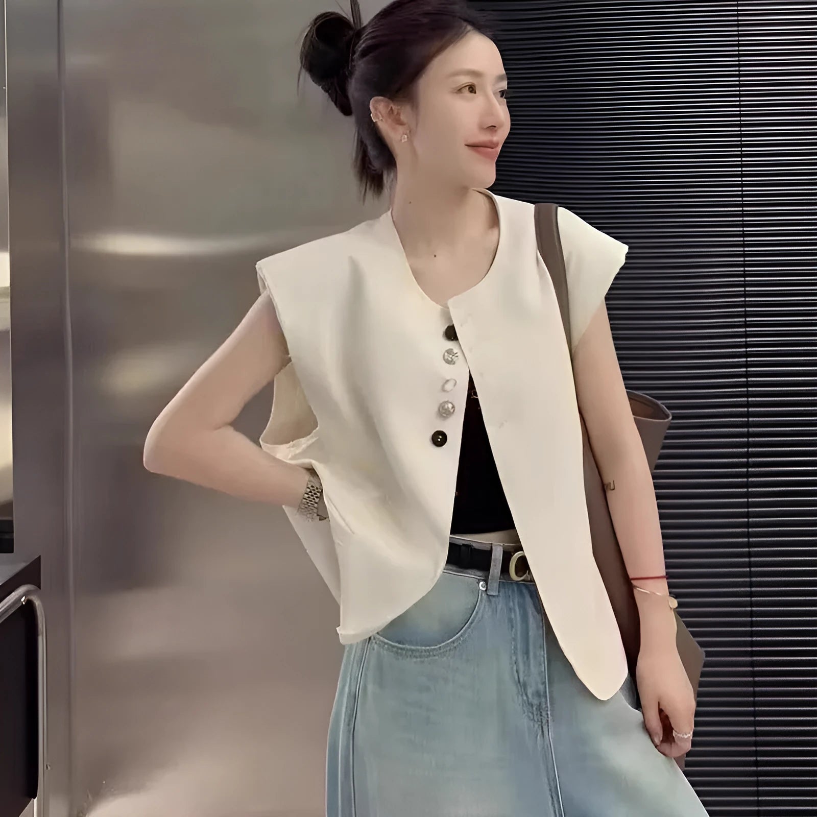Women's loose fit sleeveless vest in beige and black, showing V-neck and pocket detail.