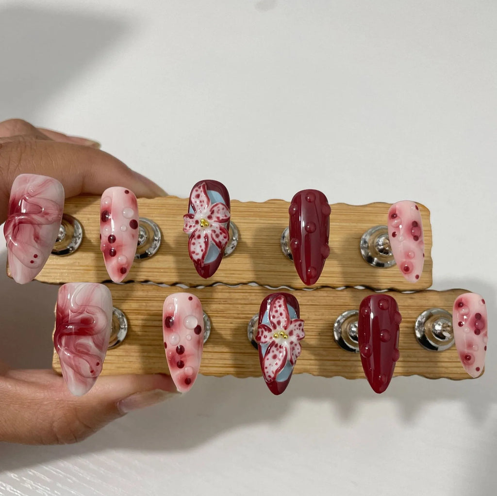 Hand-painted 3D carved manicure nail set showing rose, tulip and butterfly patterns in medium almond length