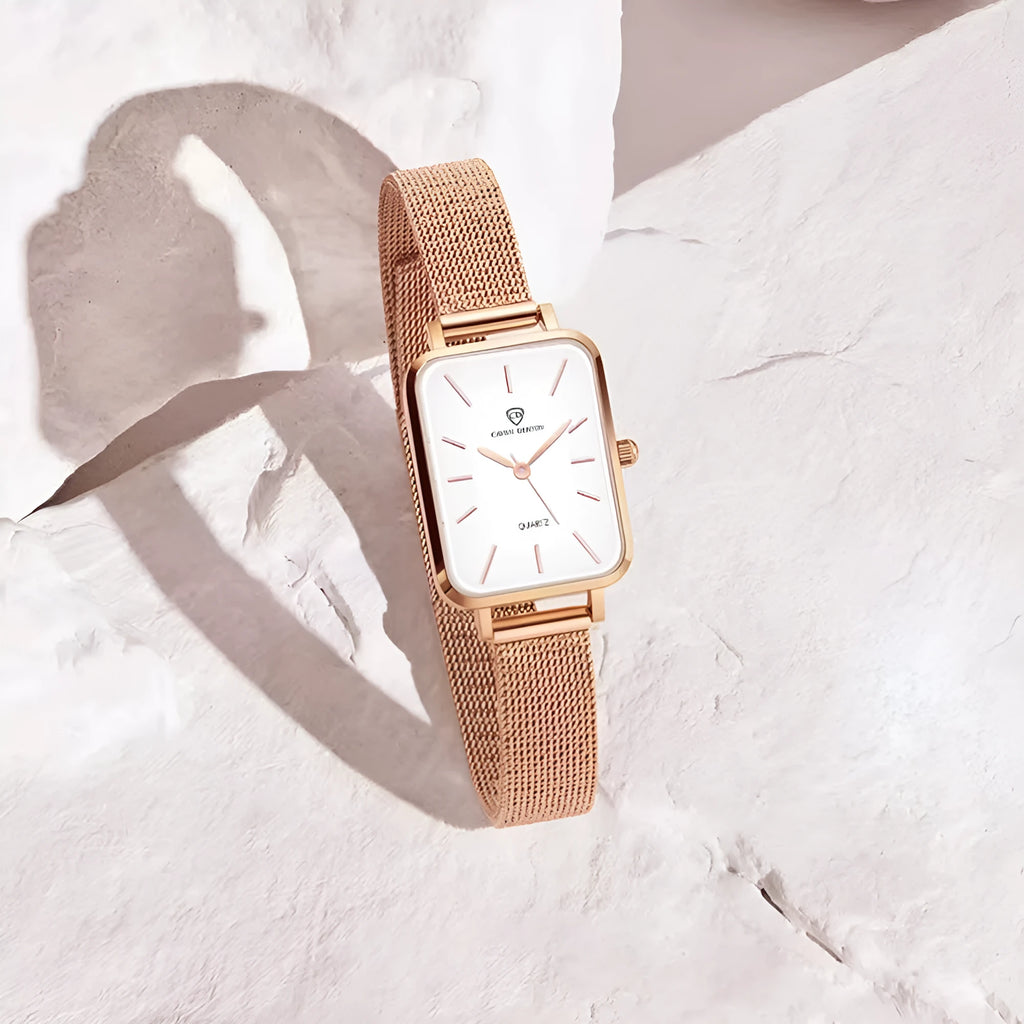 Rose gold and silver women's waterproof quartz watch with woven steel strap on a wrist.