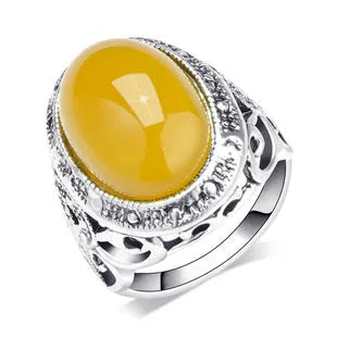 Geometric retro ring in antique silver amber colour on a grey background.