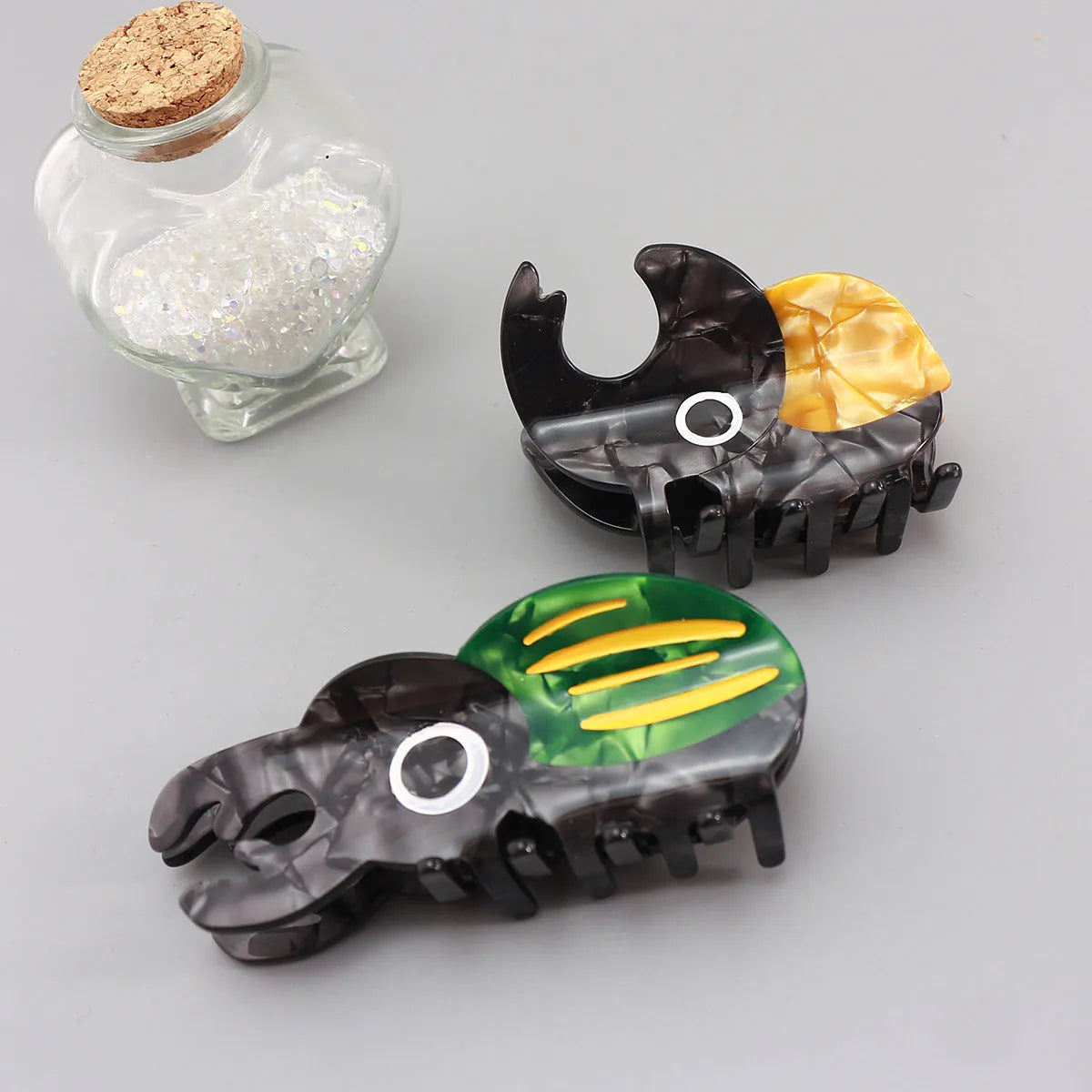 Handmade cellulose acetate beetle hair grip with cartoon caterpillar design in green, orange, or white colour options