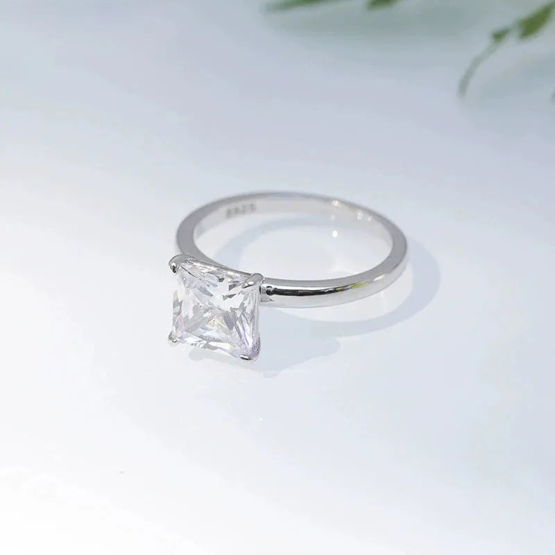 A simple geometric sterling silver ring with a round zirconia stone, shown in silver, gold, and rose gold finishes.