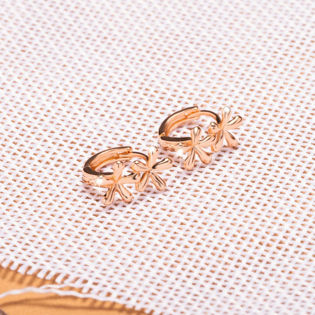 Rose gold waterdrop flower stud earrings with circular floral design on a white background.