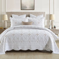 European-style embroidered pure cotton bed cover set with two pillowcases on a bed.