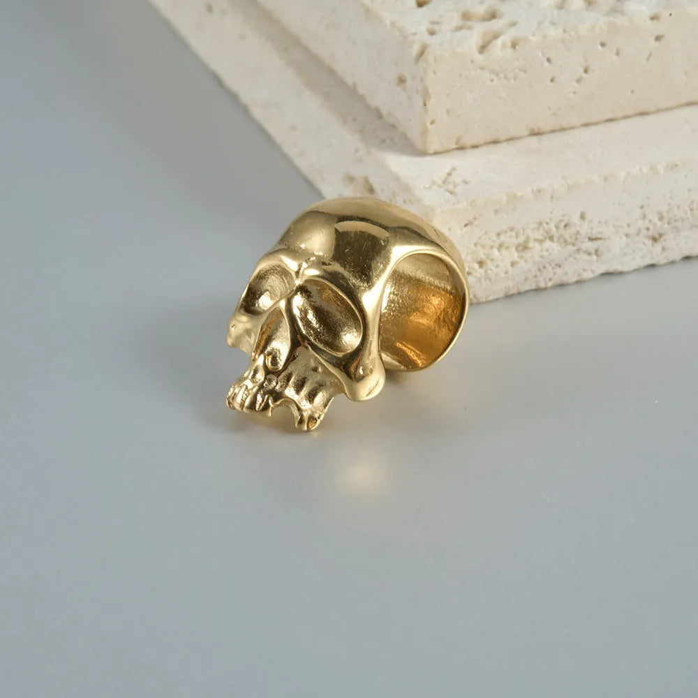 Stainless steel hollow skull and Buddha head geometric earring in hip hop style.