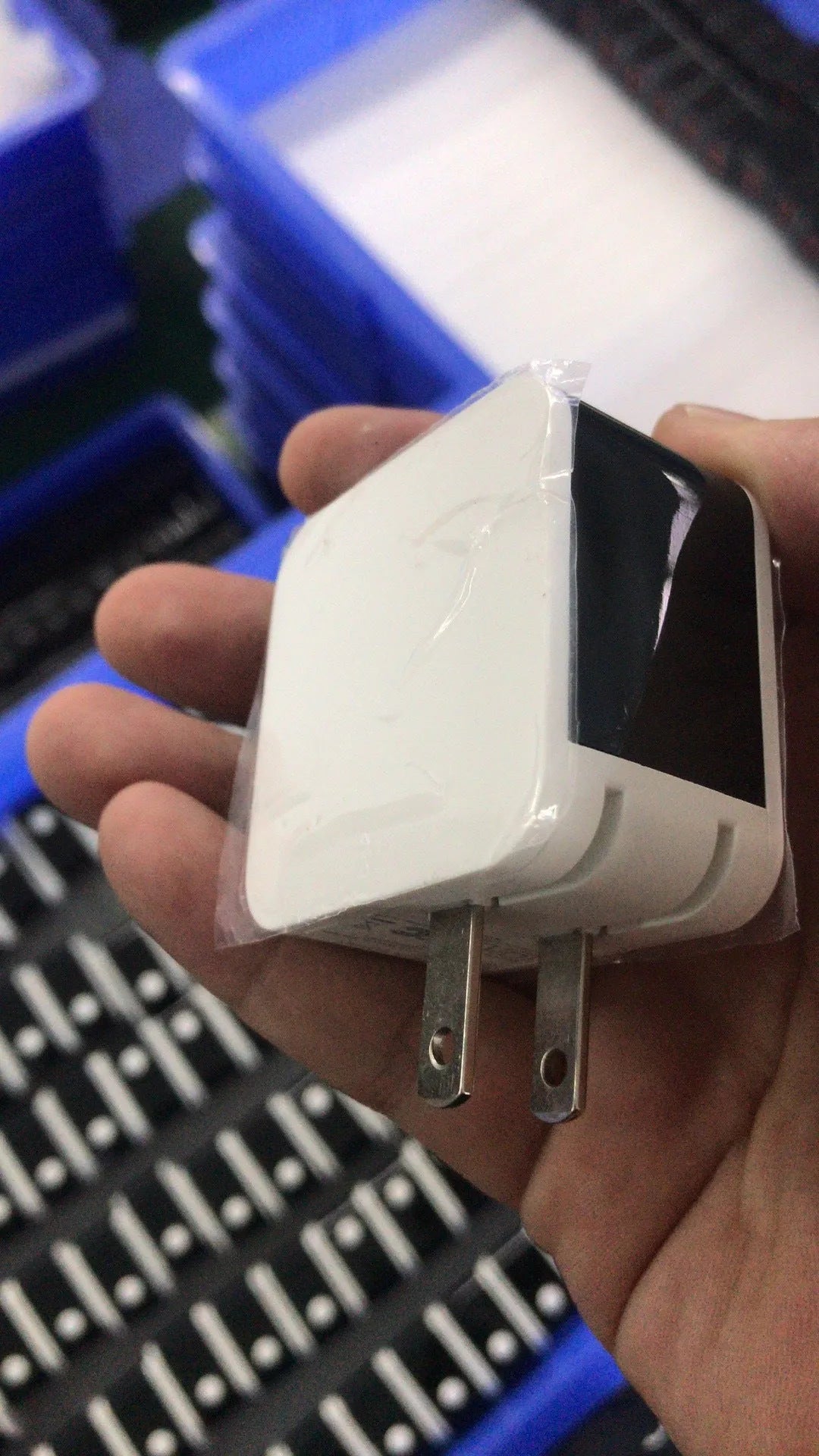 White dual USB travel wall charger with digital voltage display showing 5.0V, next to a smartphone.