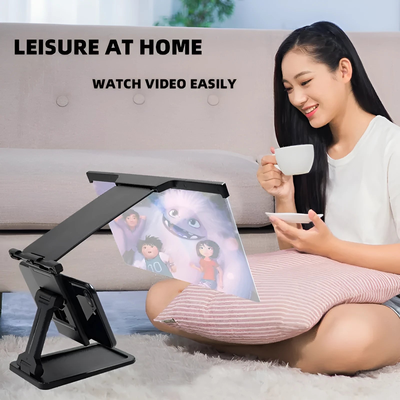 Black foldable mobile phone screen magnifier with detachable phone holder shown on a desktop.