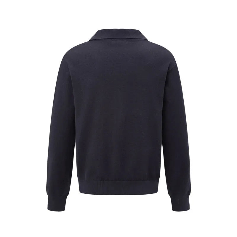 Loose fit long sleeve pullover sweater in black, dark grey, and cream colours on a hanger.