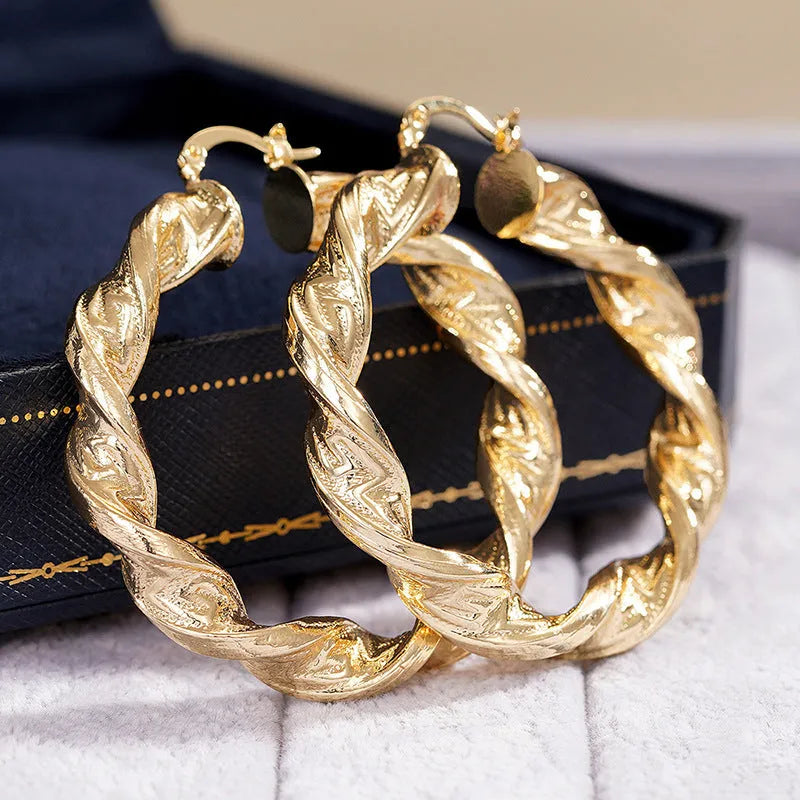 A pair of geometric design clip-on earrings for women with a drop shape and ring-and-line details.