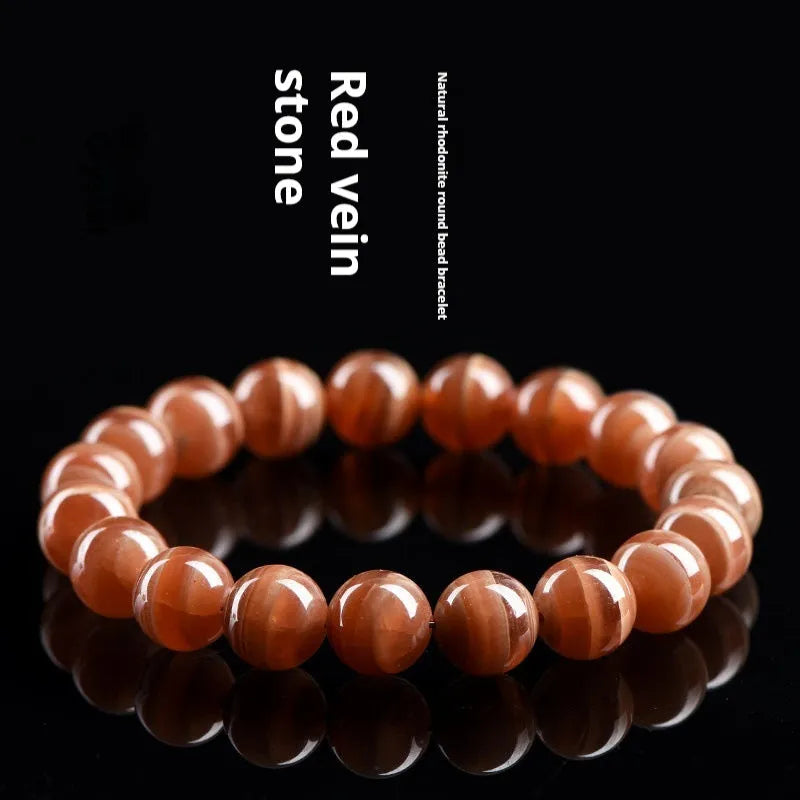 Natural Old Mine Rhodochrosite round bead bracelet with Ruyi design, shown in 6mm and 8mm sizes.