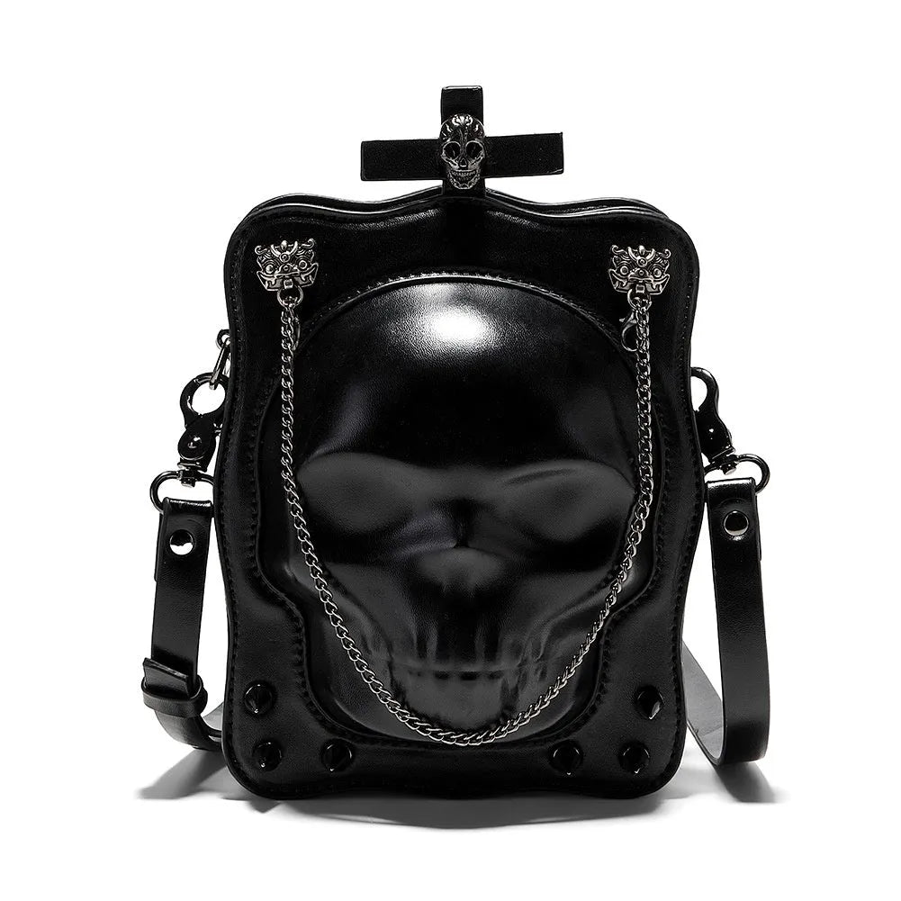 Black vertical square crossbody bag with embossed skull design, chain strap, and metal rivets.
