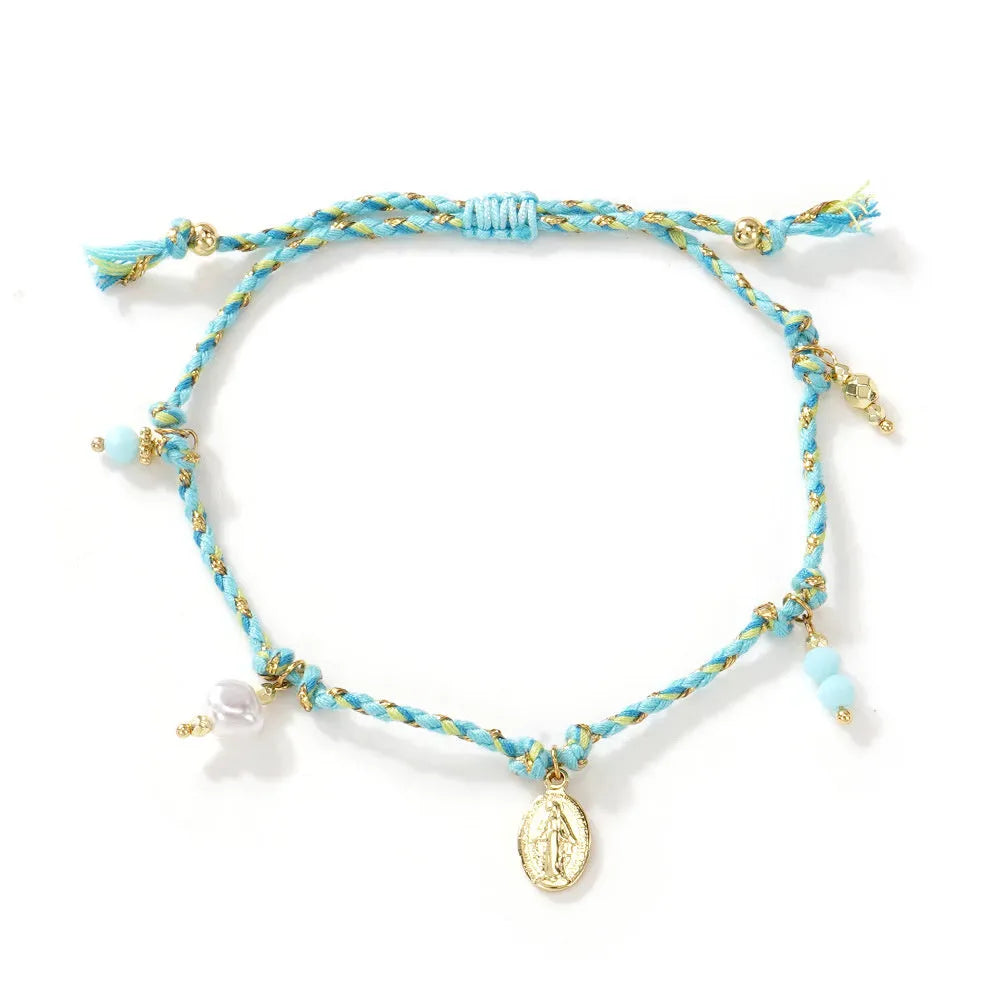Close-up of a colourful hand-woven adjustable bracelet with an ethnic-style strap tag on a wrist.