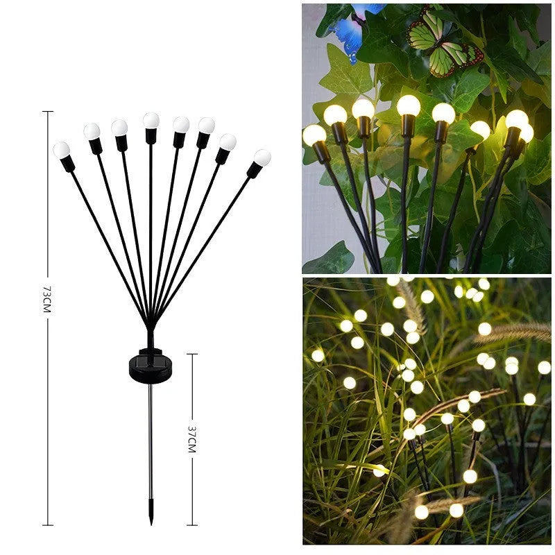 Solar-powered LED firefly garden stake light with stainless steel ground plug illuminated at dusk.