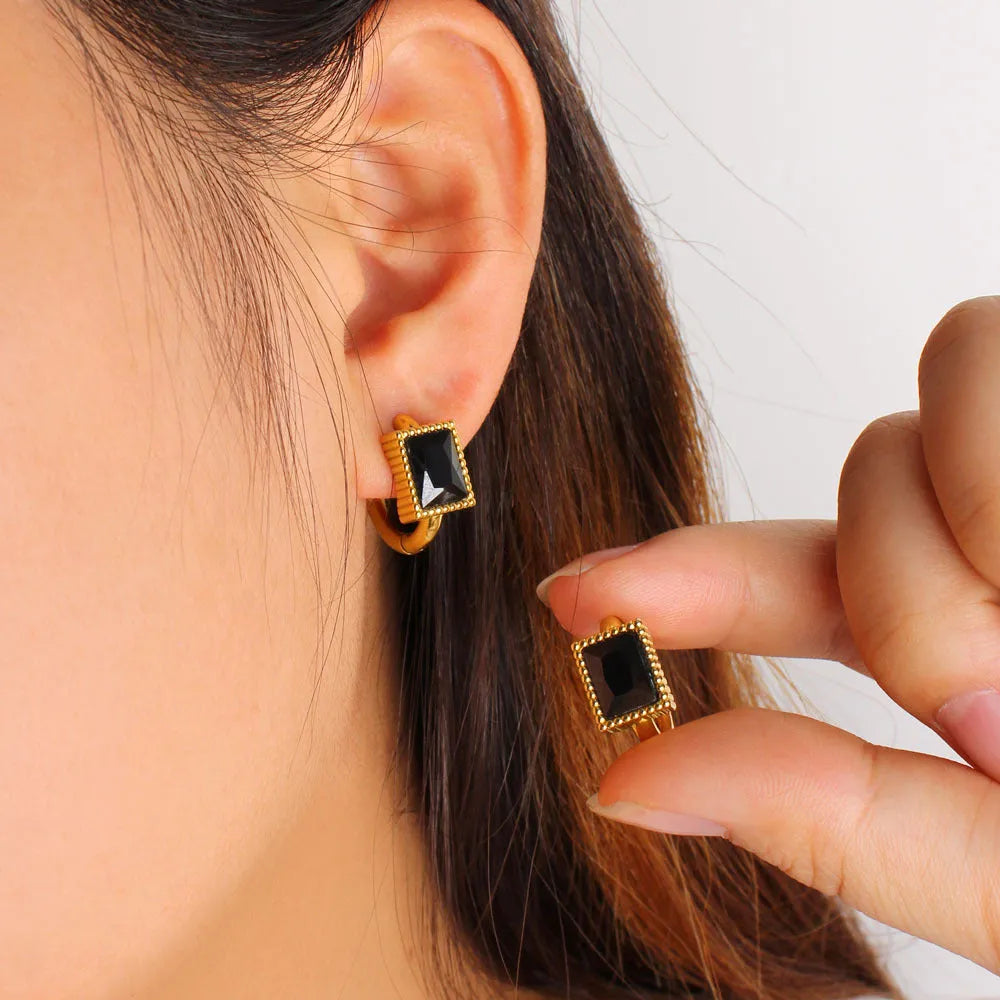A pair of square stainless steel earrings with round zircon details, shown in a choice of black, green, or white colour.