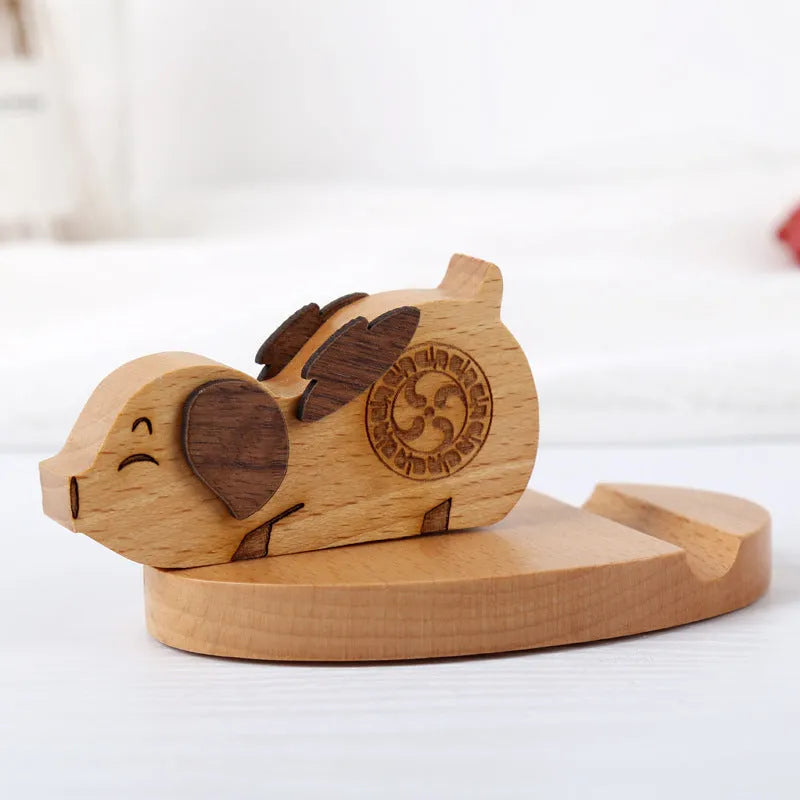 Solid beech wood phone holder with resin puppy decoration and a pound coin in the integrated slot.